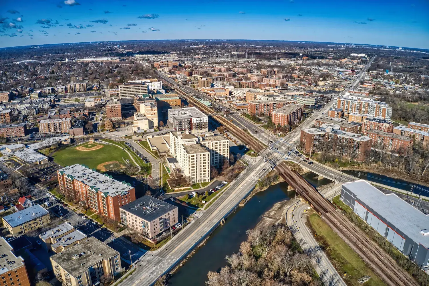 Aerial view of a city with a river and grid layout.